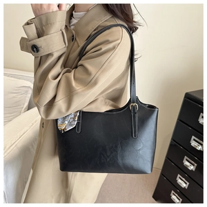 Detail of black matte tote bag with white contrast stitching and decorative printed scarf