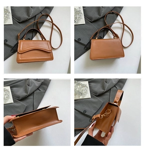 Detail view of brown leather crossbody bag with quilted curved flap and golden hardware