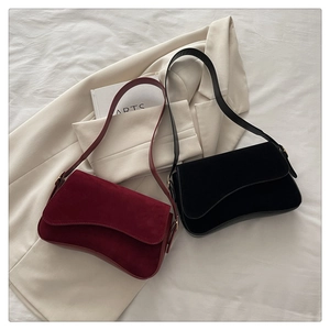 Close-up of minimalist burgundy and black matte shoulder bags with curved bottom design