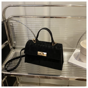 Detail of black leopard print crossbody bag with gold buckle on a stylish shelf