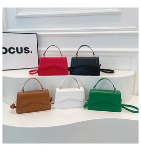 Collection of minimalist leather crossbody bags in five colors on a white display stand