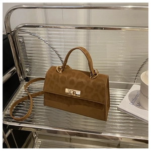 Detail of a brown suede crossbody bag with leopard print and gold metal twist lock closure