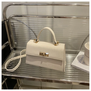 Detail of white PU leather handbag featuring a square golden twist lock and top handle