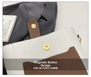 Close-up of magnetic snap design on a contrast color bucket bag with white and brown PU