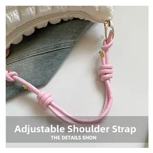 Close-up of beige textured barrel bag featuring adjustable pink knotted shoulder strap