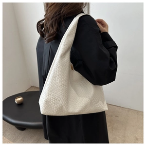Vue détaillée du sac cabas blanc tressé porté à l'épaule sur un mannequin