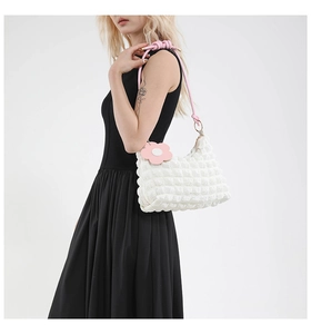 Close-up of white bubble texture fabric and pink braided strap with a sunflower charm