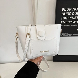 Minimalist white textured bucket bag with adjustable strap and golden magnetic buckle