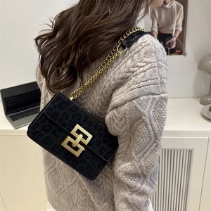 Sac bandoulière noir imprimé léopard avec boucle dorée et bandoulière chaîne sur modèle