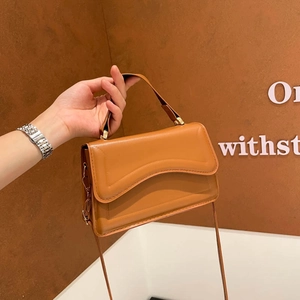 Minimalist caramel brown leather shoulder bag with stylish wavy stitching and gold hardware