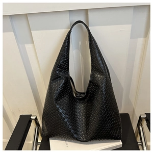 Détail d'un sac cabas noir en cuir tressé avec motif Intrecciato et bandoulière large