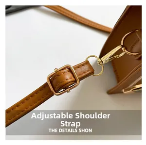 Detail of adjustable caramel leather shoulder strap with golden metal buckle and clasp