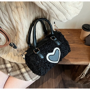 Close-up of black fuzzy lamb wool handbag featuring a large white heart pattern design