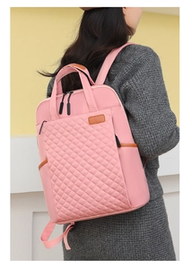 Sac à dos en nylon matelassé rose avec détails en cuir porté par un mannequin pour le travail