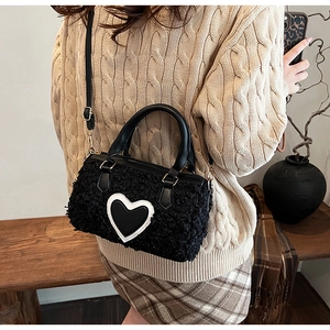 Detail of black faux fur plush crossbody bag featuring heart leather patch decoration
