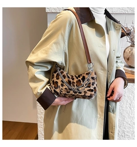 Detail of plush leopard print shoulder bag featuring gold chain and leather strap details