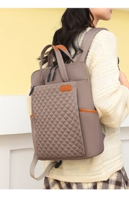 Sac à dos taupe en tissu Oxford avec matelassage en losanges porté par un mannequin