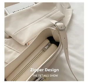 Detailed close-up of smooth zipper design on minimalist beige faux leather shoulder bag