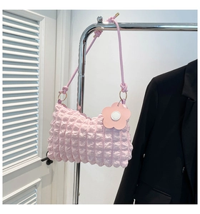 Close-up of pink bubble texture fabric on a cylindrical bag with a floral charm
