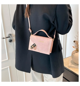 Detail of pink shoulder bag with gold clasp and chain on model's outfit