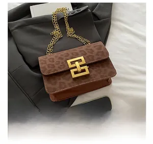 Detail showing the leopard print suede fabric and golden geometric lock of the bag