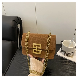 Close-up of brown leopard embossed suede shoulder bag with gold chain and geometric lock