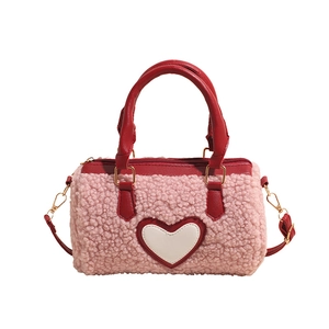 Pink faux lamb fur crossbody pillow bag with red leather heart accent and golden hardware