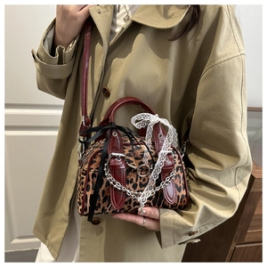 Detail of leopard print faux fur crossbody bag with red trim and lace edge on a model