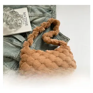 Dettaglio borsa tote in peluche cammello con trama a bolle su giacca di jeans