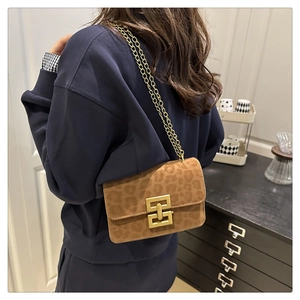 Detail of leopard print crossbody bag with gold chain strap and geometric metal lock