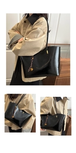 Detail of black oil wax leather tote bag with elegant golden ball charm and long straps