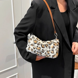 Leopard print plush underarm bag with metal chain and brown leather shoulder strap on model