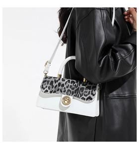 Detail of white leather bag with leopard print flap and golden turn-lock fastener
