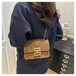 Detail of leopard print suede crossbody bag with gold chain strap and large metal buckle