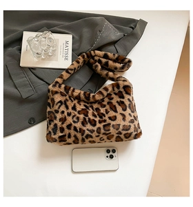 Vue détaillée du sac bandoulière en fausse fourrure léopard sur un bureau élégant