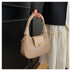 Dettaglio borsa a tracolla beige intrecciata con fibbia metallica e design a mezzaluna
