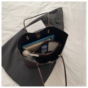 Top view of a spacious brown tote bag interior showing compartments for tablet and essentials