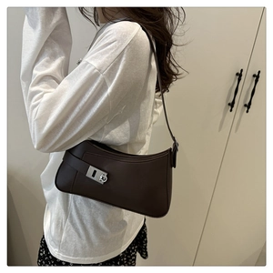 Brown leather hobo bag shoulder view on white shirt and floral skirt outfit