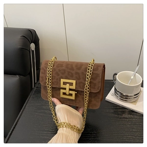 Close-up of leopard print suede crossbody bag with gold square lock and chain strap
