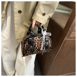 Close-up of leopard print Boston bag featuring silver buckles and white lace bow detail