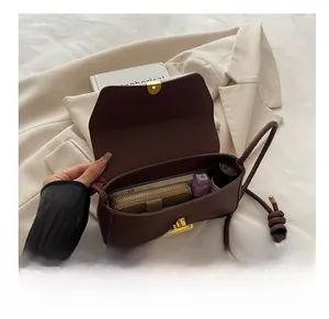 Detail view of the interior capacity of a brown crossbody bag with a wallet and phone