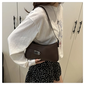 Detail view of the silver metal clasp and smooth brown leather on the hobo shoulder bag
