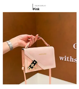 Detail of pink faux suede crossbody bag with gold chain and metal clasp closure