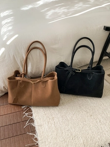 Large minimalist tote bags in black and brown suede finish for women on a cozy background