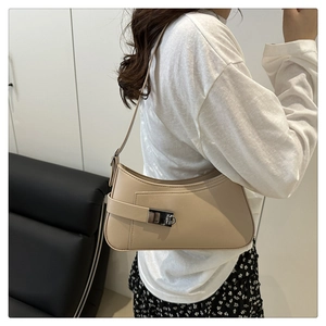 Model wearing a minimalist apricot shoulder bag featuring a stylish metal lock buckle