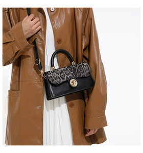 Detail of leopard print flap bag with gold twist lock and adjustable shoulder strap