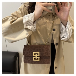 Detail of leopard print suede flap bag with vintage golden metal twist lock and chain strap