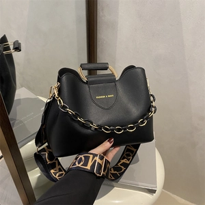 Modern black leather bucket bag with gold handle and geometric pattern wide strap
