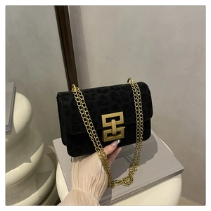 Detail of black leopard print suede bag with gold chain and square metallic buckle