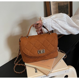 Detail of brown quilted matte crossbody bag with metal twist lock and chain strap